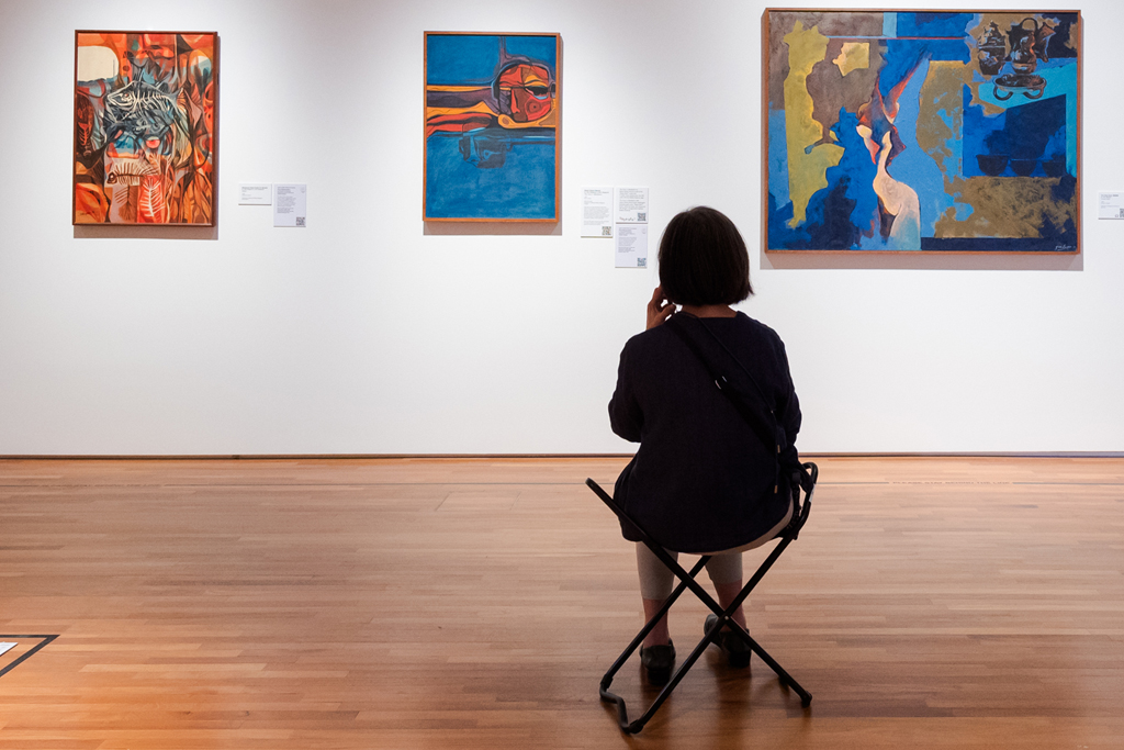 A visitor contemplating one of the featured artworks in the Slow Art audio guides