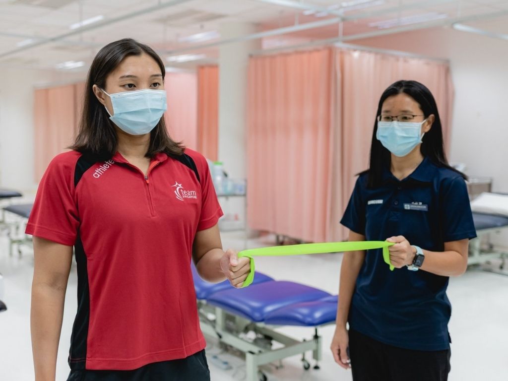 Suelyn conducting strengthening exercises with Team Singapore athlete Nur Marina Chan 